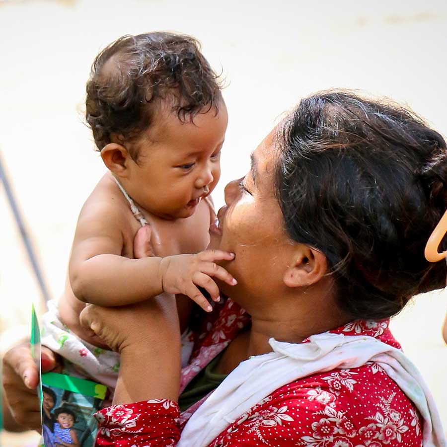 A close up shot of a Cambodian mother embracing her baby daughter